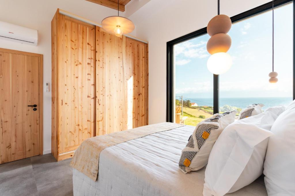 a bedroom with a bed and a large window at Casa Al Mare in Canto da Areia