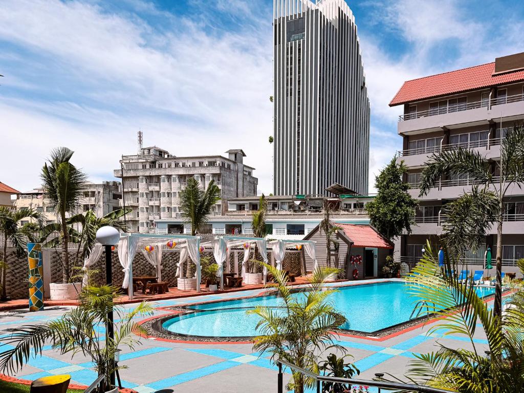 a large swimming pool in a city with tall buildings at The Holiday Resort Pattaya in Pattaya