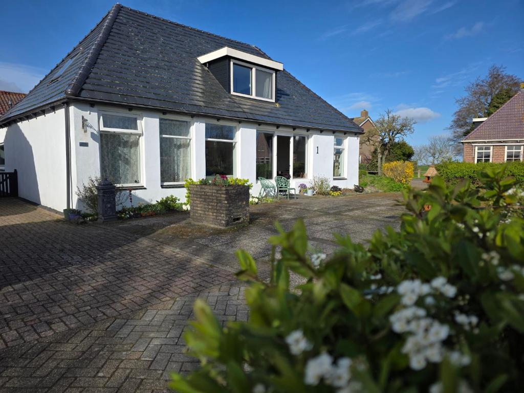 a white house with a black roof at B&B Bokkeleane in Kolderwolde