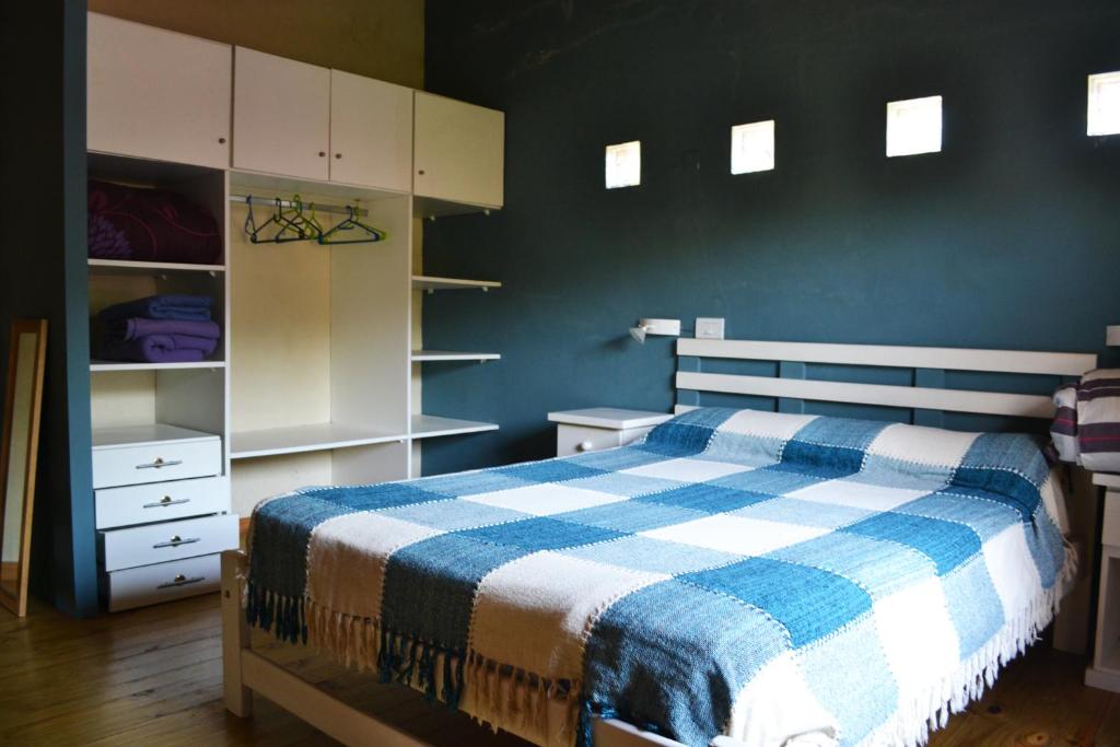 1 dormitorio con 1 cama con manta azul y blanca en Duplex Don Eduardo en Ostende