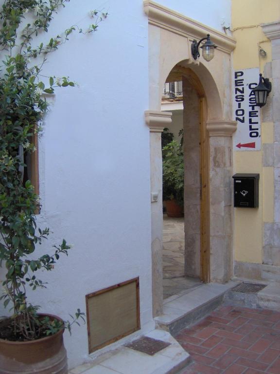 an entrance to a white building with an archway at Pension Castello in Rethymno