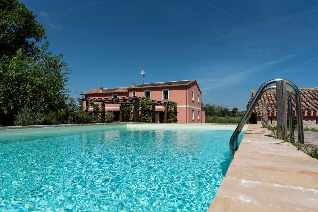 a swimming pool with a slide in front of a house at All'ombra della quercia in Fano