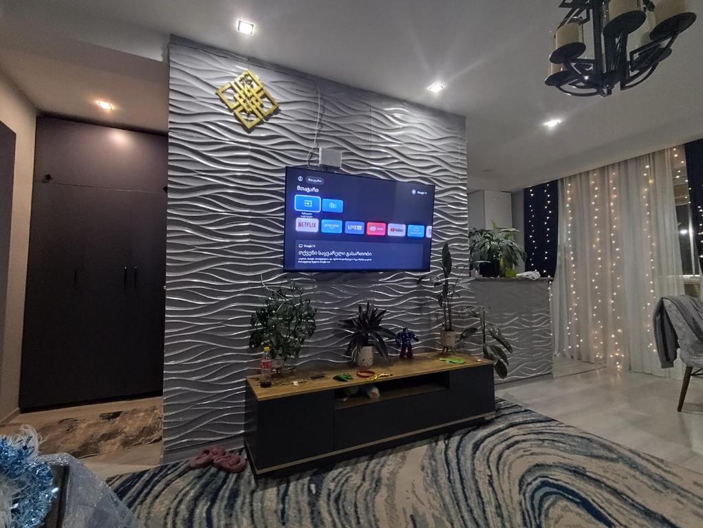 a living room with a large screen tv on a wall at Deako in Kobuleti