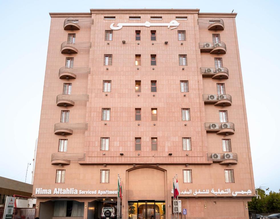 a large brick building with a sign on it at Hima Al Tahliyah Serviced Apartments in Jeddah