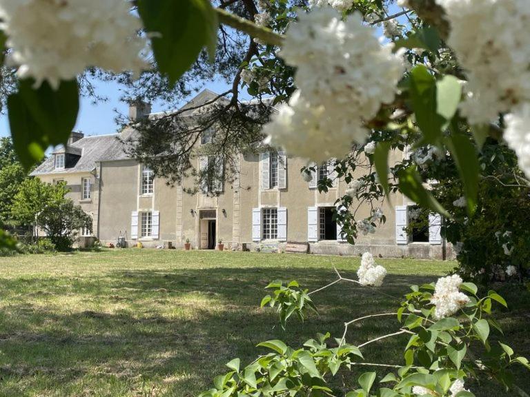 a large house with white flowers in front of it at Château de Saint Clair in Saint-Clair-sur-lʼElle