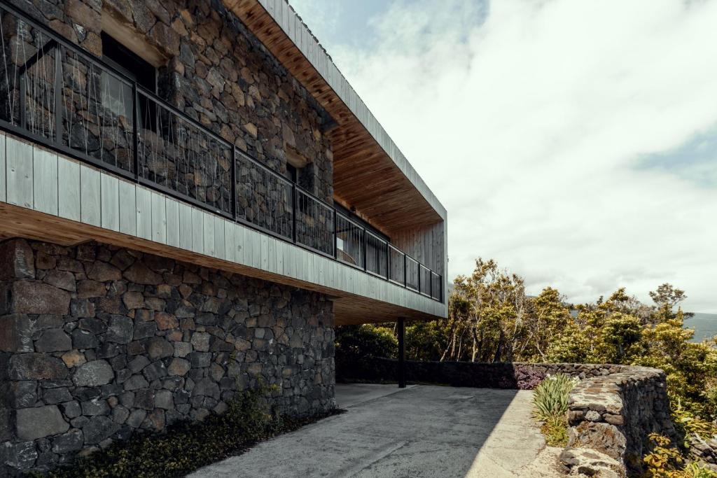 a stone building with a balcony on the side of it at Casa da Faia in São Roque do Pico