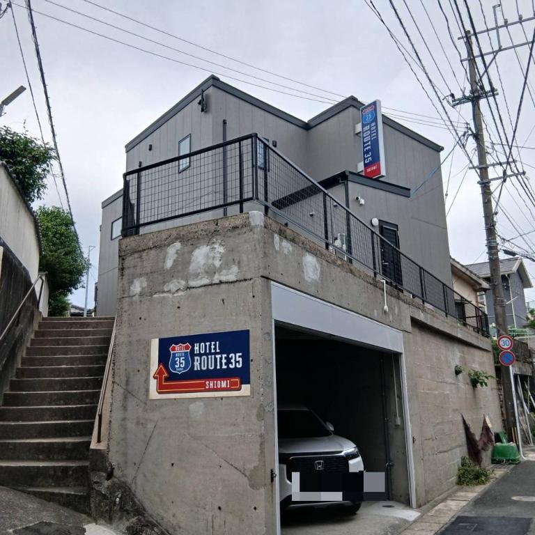 a building with a garage with a car in it at Hotel Route35 Shiomi in Sasebo
