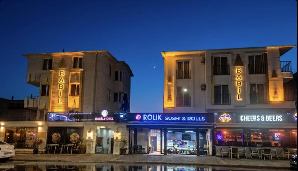 two buildings with neon signs in a city at night at Babil Hotel in Antalya