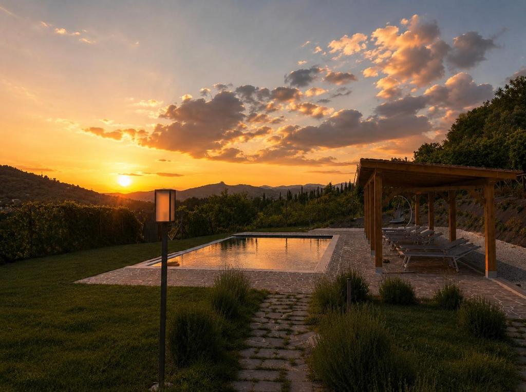 a swimming pool with a sunset in the background at Tenuta di Valmarino - Adults only in Corciano