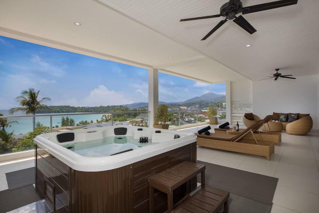 a large room with a bath tub and a large window at Kata Seaview Jacuzzi Suite - Pasifora in Kata Beach