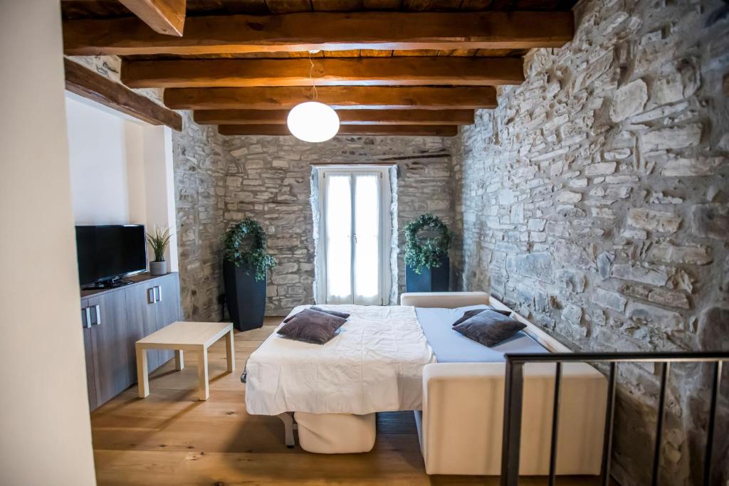 a bedroom with a bed and a stone wall at Borgo Molina in Faggeto Lario 