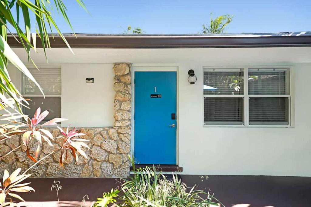 a blue door on a white house at Beach Apart by Dream Vacation unit 1 in West Palm Beach