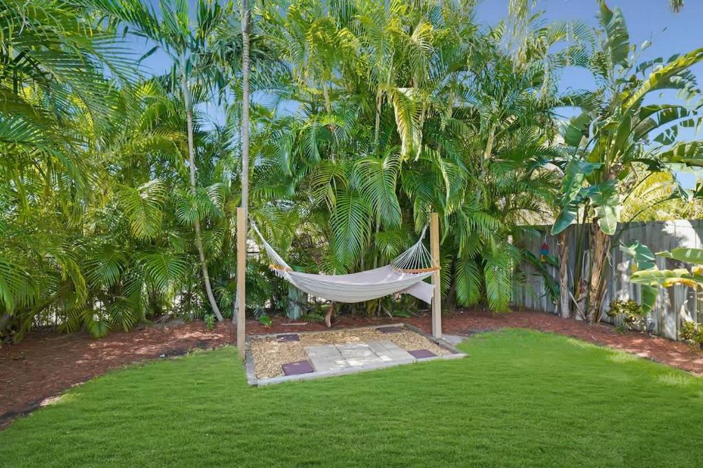 a hammock in a yard with palm trees at Beach Apart by Dream Vacation unit 3 in West Palm Beach