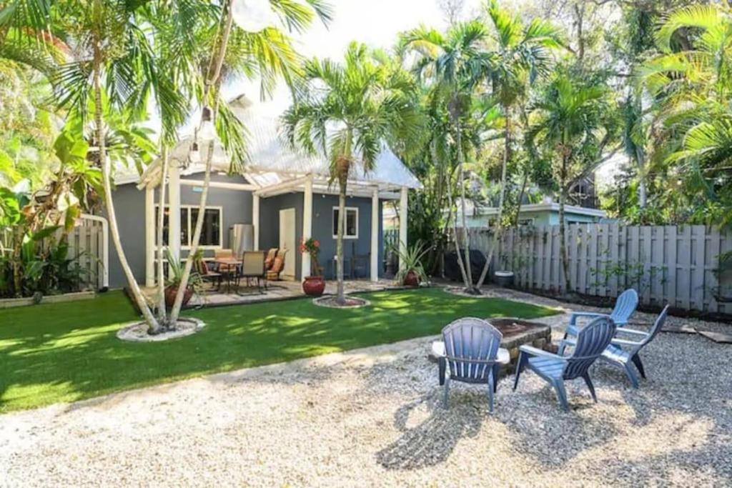 a home with palm trees and chairs in the yard at Peacock Villa 2 by Dream Vacation in Fort Lauderdale