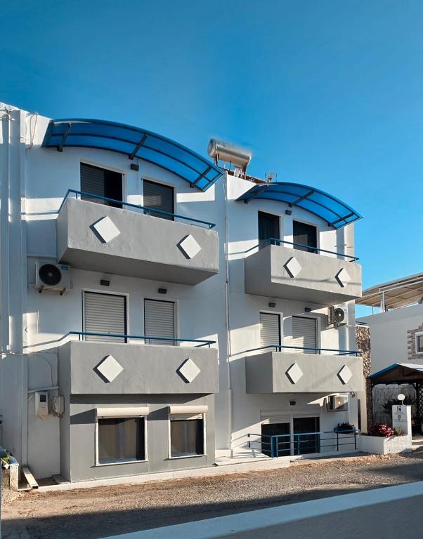 a white building with balconies on the side of it at Marika Apartments in Mastihari