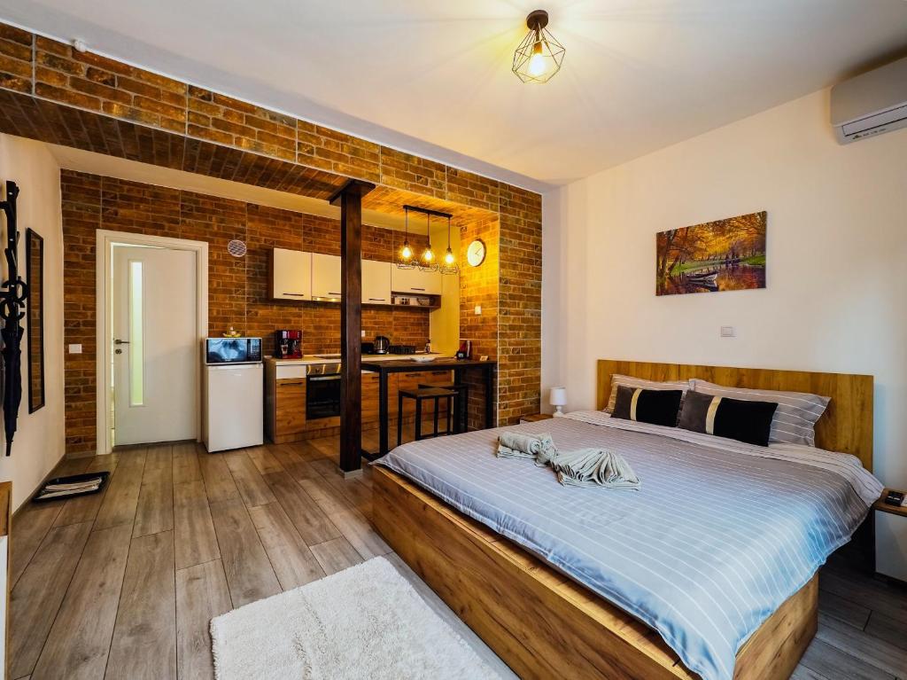 a bedroom with a bed and a brick wall at Ben Apartments Near City Center in Sibiu