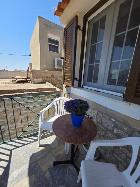 a patio with two chairs and a table with a potted plant at Sidirounda Traditional House 1 in Sidiroúnta