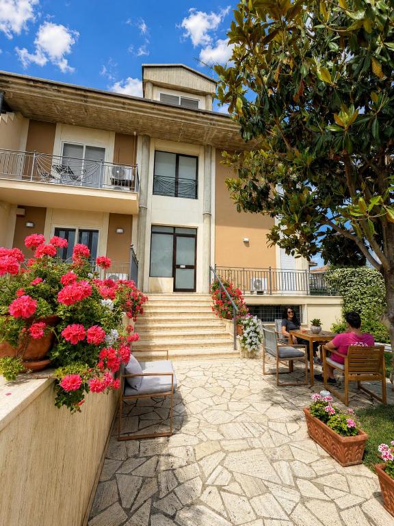 a house with stairs and flowers in front of it at Avola Garden Apartment near Pantanello Beach in Avola