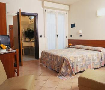 a hotel room with a bed and a television at Hotel Numi & Medusa in Cesenatico