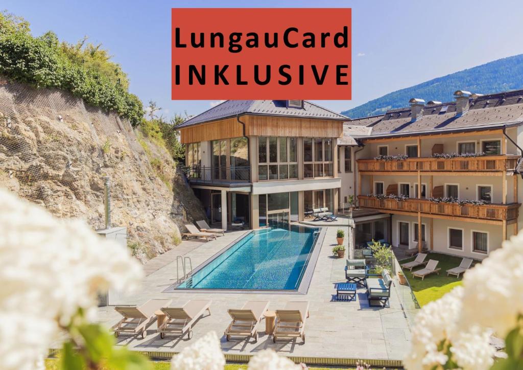 a villa with a swimming pool and a house at Hotel Weissenstein in Sankt Michael im Lungau