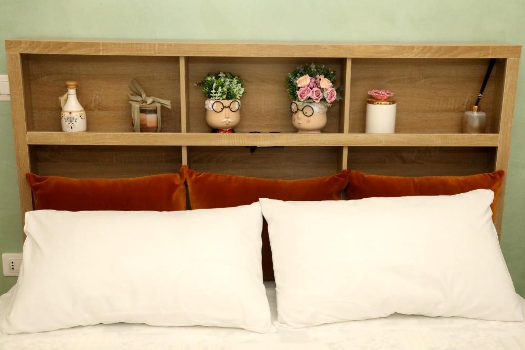 a shelf with plants and vases on top of a bed at La Rosa di Antonio & Relax Room in Tricase