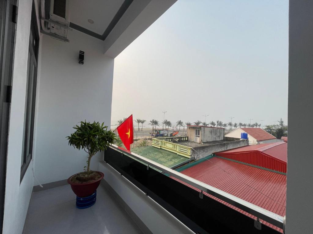 a balcony with a plant and a flag at Khách Sạn Long Dung in Nam Khê