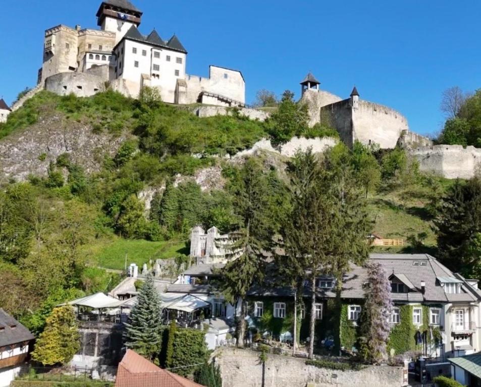 a castle on top of a hill with houses at Hotel Fatima in Trenčín