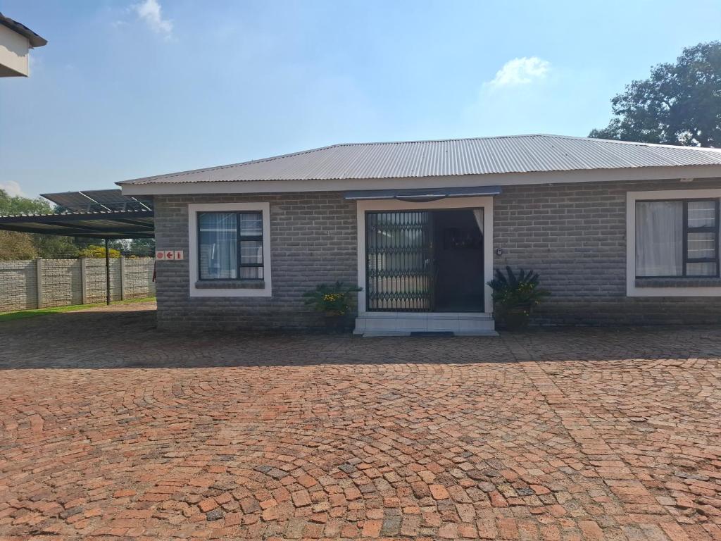 a brick house with a brick driveway at CE Guesthouse in Vanderbijlpark