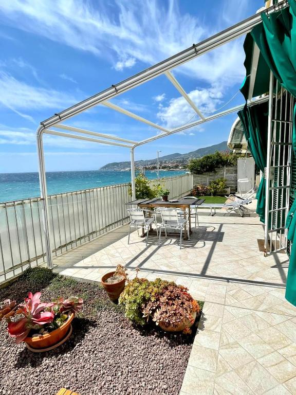a patio with a table and chairs and the ocean at Perfect Wave a 10 m dal mare in Sanremo