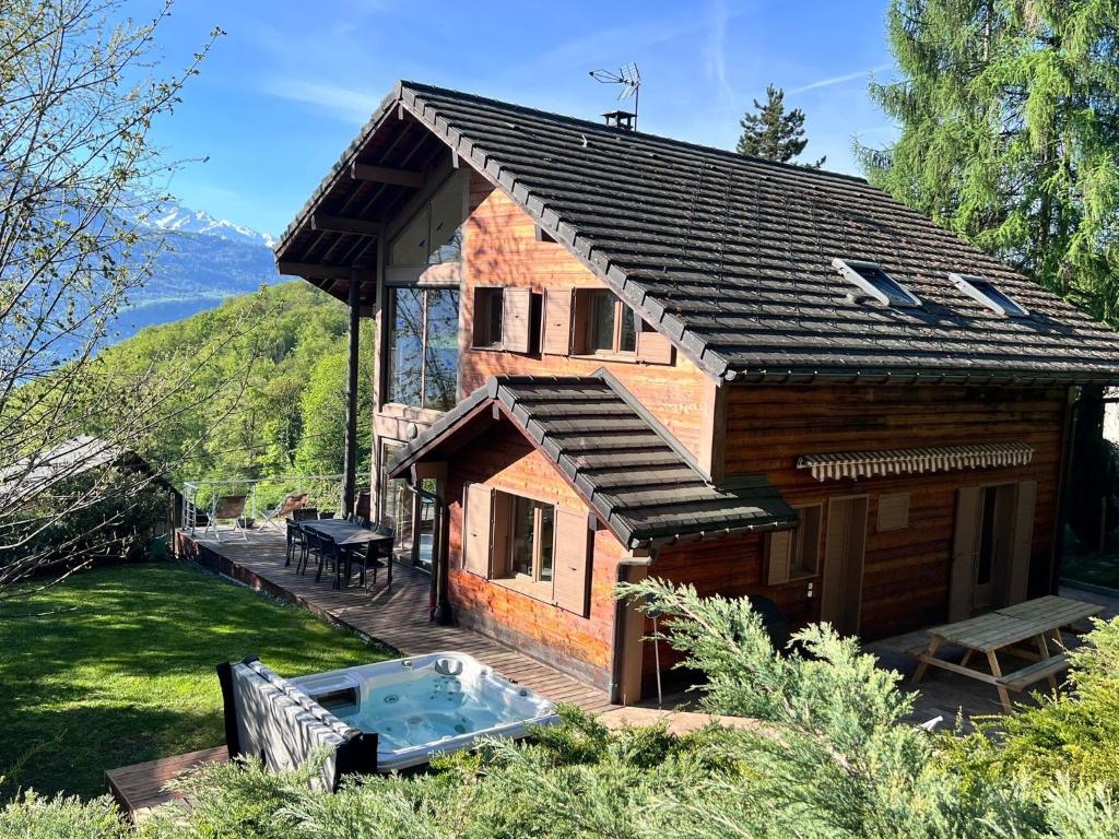 a house with a hot tub in the yard at Chalet Coeur de Savoie in Cléry