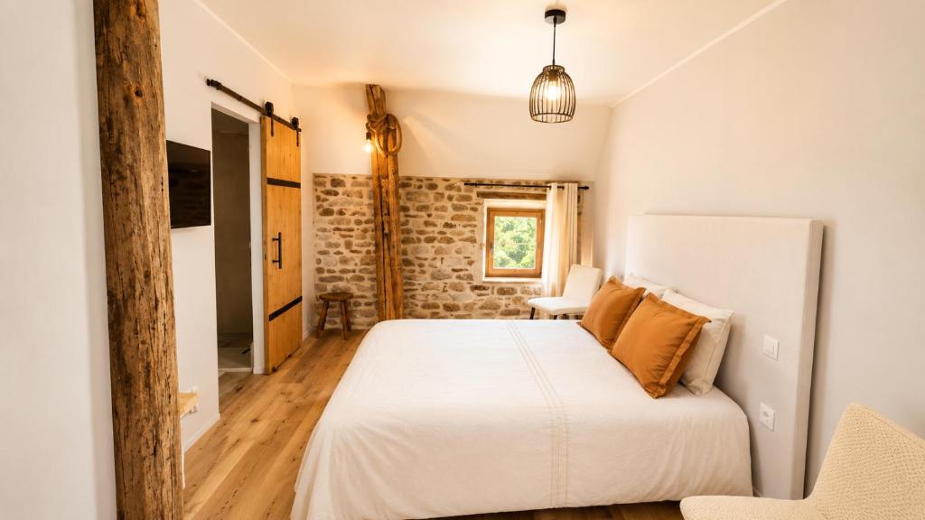 a bedroom with a white bed and a chair at Chambres d'Hôtes du Manoir du Haut Salmon in Saint Malo