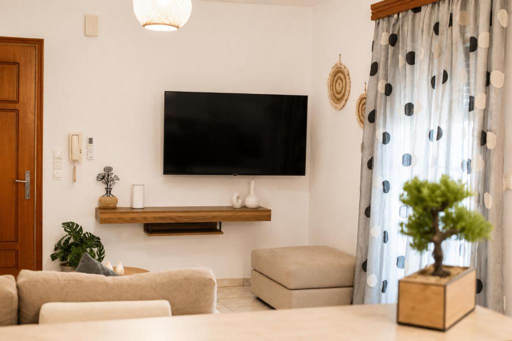 a living room with a flat screen tv on a wall at Indaba Luxury Apartments in Myrina