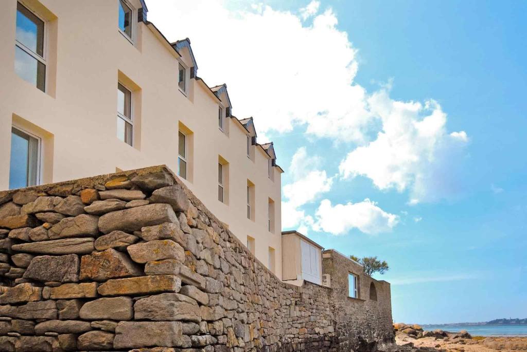 a stone wall in front of a building at Ibis Roscoff Bord de Mer in Roscoff