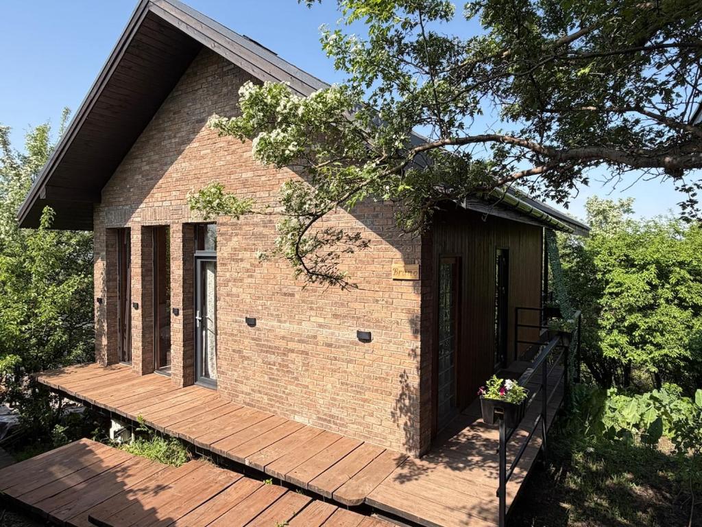 a small brick house with a wooden deck at Bruno House in Almaty