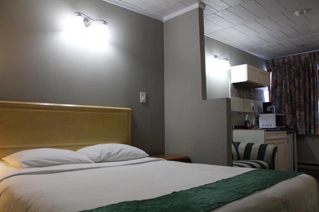 Habitación de hotel con cama y silla en Ritz Inn Niagara en Cataratas del Niágara