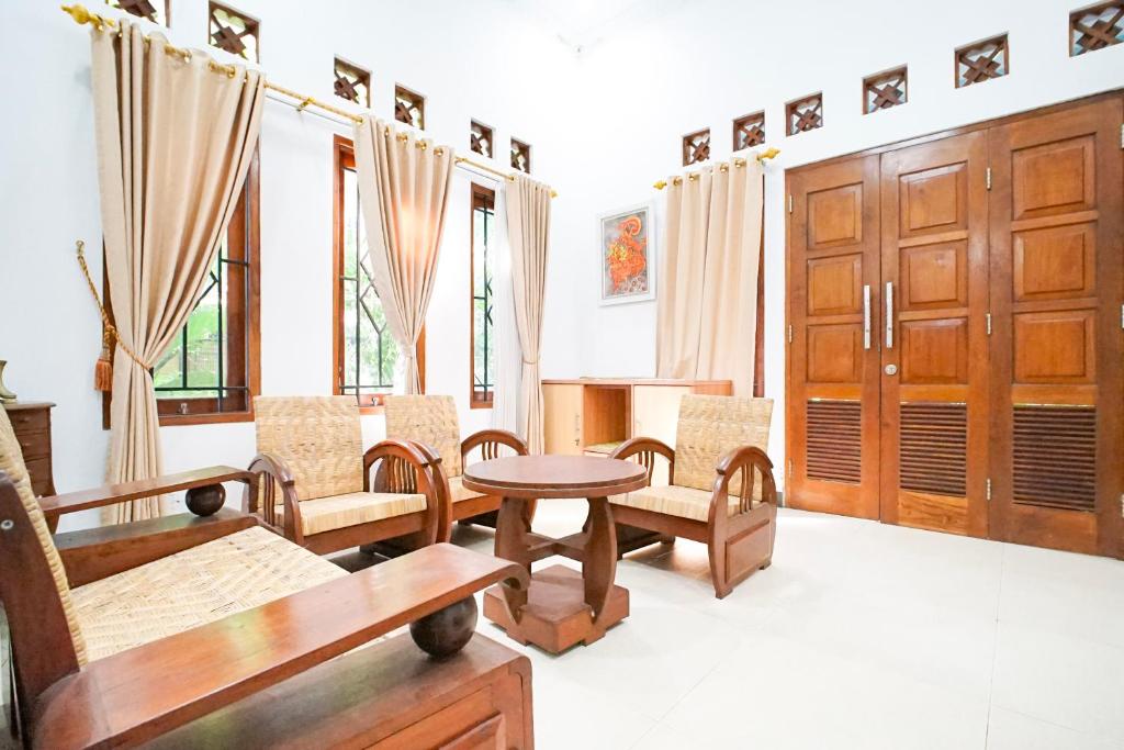 a living room with wooden furniture and a table at Ndalem Artho in Beran-kidul
