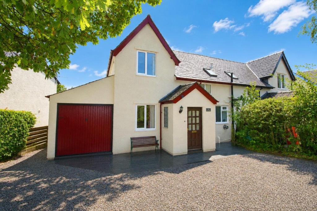 a detached house with a red garage at Hill Cottage, Braithwaite with garden and fell views, dog friendly walks from the door, close to Bassenthwaite in Braithwaite