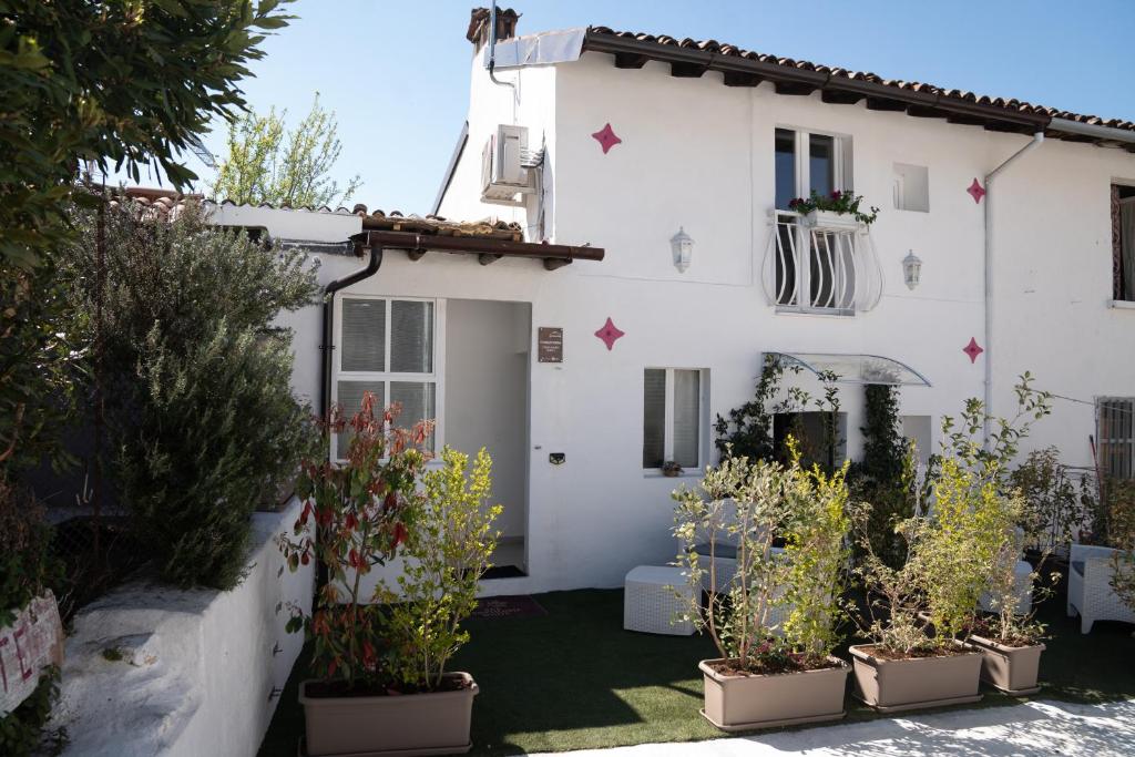 a white house with potted plants in front of it at Franciacorta White in Cellatica