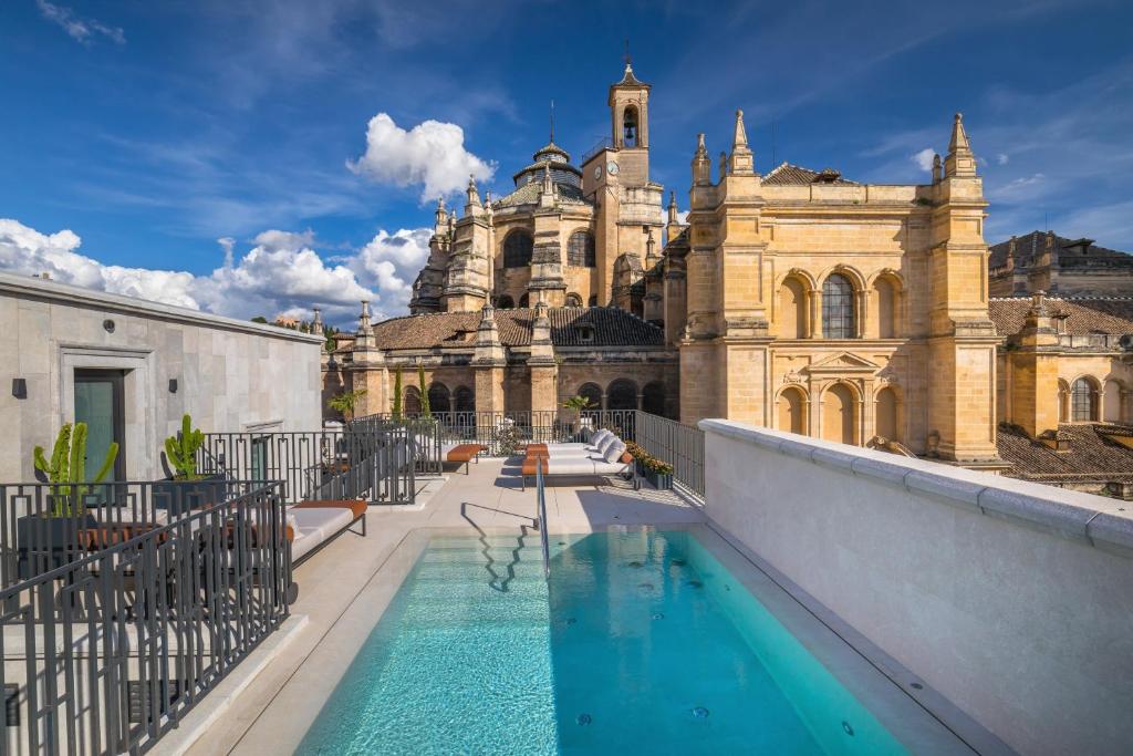 a building with a swimming pool in front of a building at Gran Hotel Claridge Granada - Preferred Hotels & Resorts in Granada