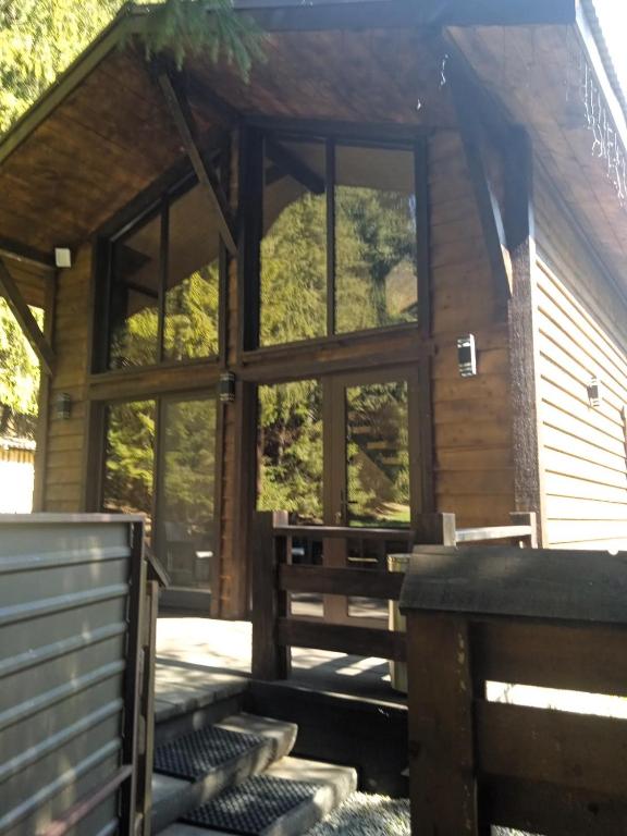 a log cabin with large windows and a porch at Котедж Арпад in Synevyr