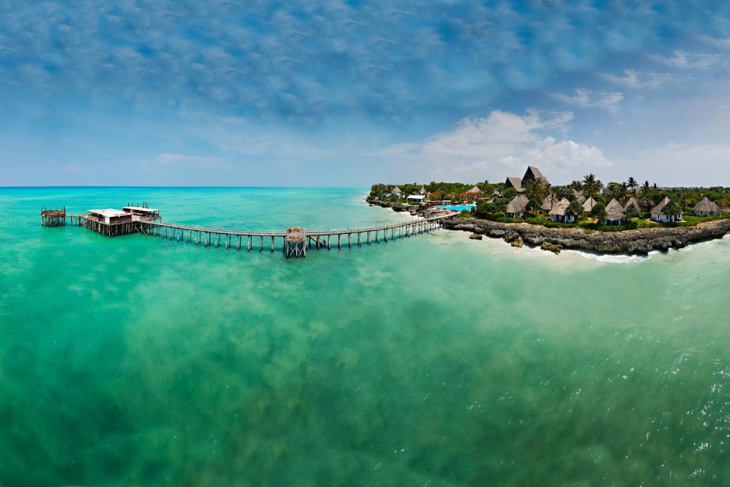 an island in the ocean with a dock in the water at Essque Zalu Zanzibar in Nungwi