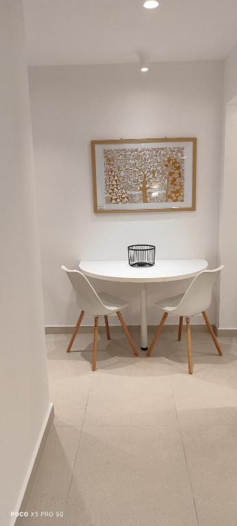 a white table and two chairs in a room at Papadioti Apartments in Pefki
