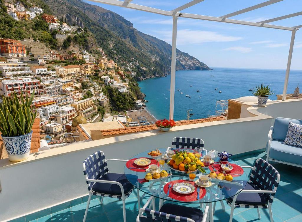 a table with a bowl of fruit on top of a balcony at Villa Positano with sea view ! in Positano