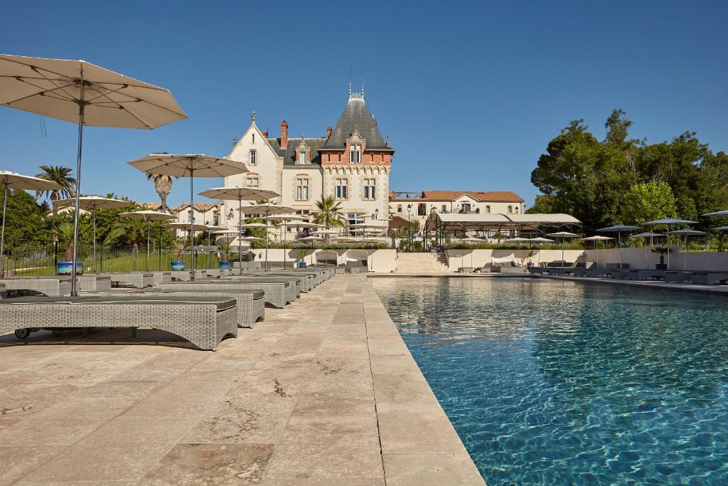 a resort with a swimming pool and a building at Château St Pierre de Serjac in Puissalicon