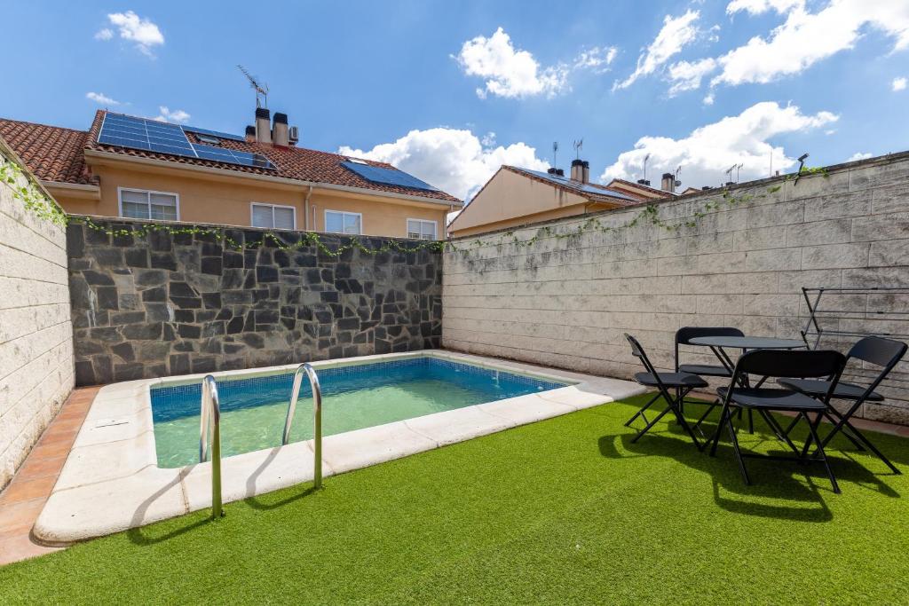 a backyard with a swimming pool and two chairs and a table at Semi-detached Hse in Loeches