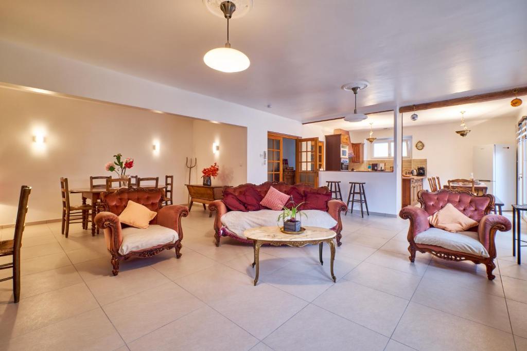 a living room with two couches and a table at Chez Emile in Brézins