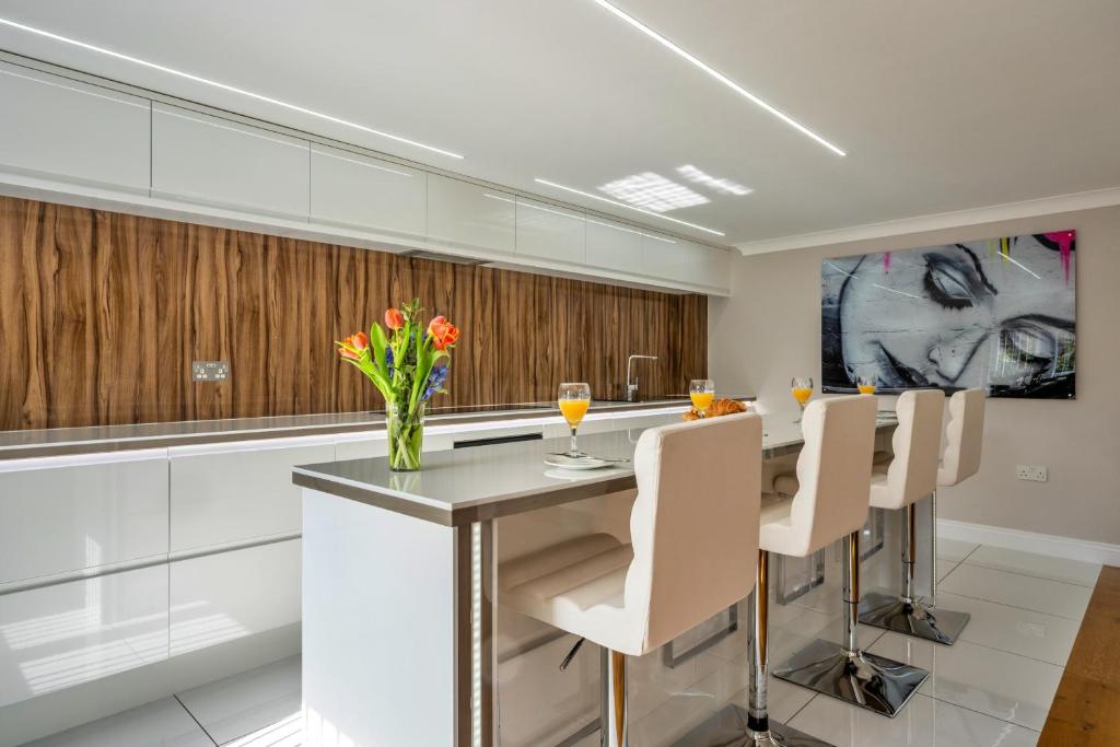 a kitchen with a table with chairs and a vase of flowers at Finest Retreats - Hollies Coach House in Martock