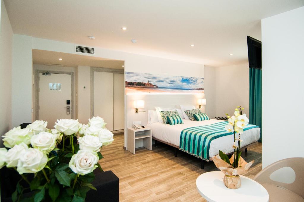 a hotel room with a bed and white roses at Hotel Censal in Villajoyosa