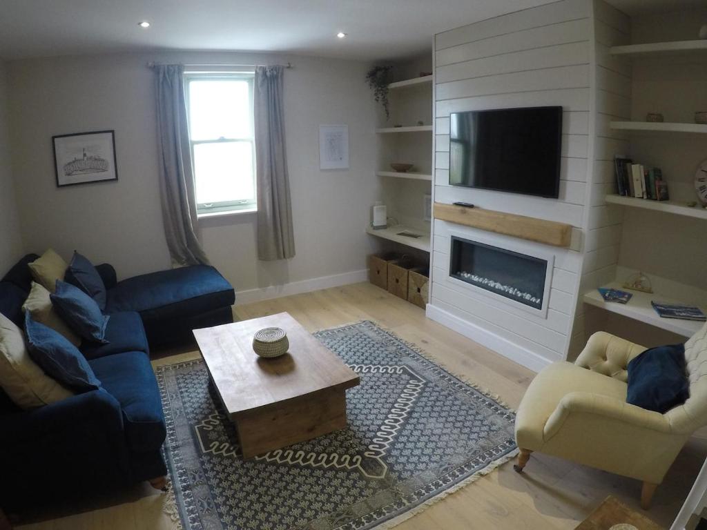 a living room with a couch a table and a tv at Storm View in Castletown