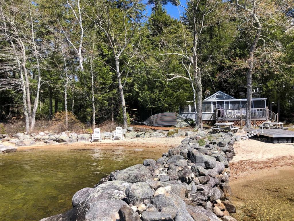 a house on the shore of a body of water at BEACHSIDE ON SEBAGO LIMIT 6 villa in Standish